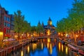 Canal and St Nicholas Church in Amsterdam at twilight, Netherlands. Famous Amsterdam landmark near Central Station. Royalty Free Stock Photo