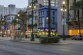 Canal Street with liquor stores, restaurants and shops along the street, people walking, cars driving on the street