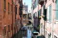 Canal streets of Venice with motorboats anchored at walls of old houses.