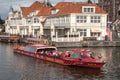 Canal tour boat giving tourist rides. Urban landscape and historic building