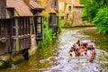 Canal with tour boat and swans along historic houses Bruges Belgium Royalty Free Stock Photo