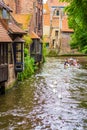 Canal with tour boat swans historic houses Bruges Belgium Royalty Free Stock Photo