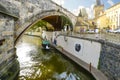 A canal with a tourist boat under a bridge on Kampa Island in Prague, Czechia