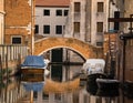 Canal in Venice, Italy with boats docked and reflections on the water