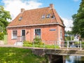 Canal with waterfront house and bridge in old town of Dokkum, Fr