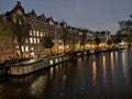 Canals, bridge, bike and houses of Amsterdam city, in Holland, Netherlands at night