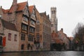 The canals of Brugge with the Hotel Relais Bourgondisch Cruyce with Belfry of Bruges in the distance