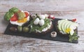 Canape with avocado, mozzarella ,tomato,pesto,olives, cream cheese. Mix of different snacks and appetizers Royalty Free Stock Photo