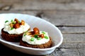 Canape with cottage cheese, mushrooms and green onion on a plate on a wooden background