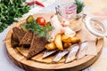 Canape with salted herring fish with potatoes slices and red onion, pickles, cucumber, cherry tomato, fat, dill, rye Royalty Free Stock Photo