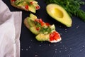 Canape - slices of crispy baguette with slices of ripe avocado and slices of juicy tomato, sprinkled with sesame seeds and