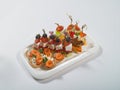 Canapes of fish, vegetables, meat on a plate on a white background Royalty Free Stock Photo