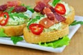 Canapes with herbed cream cheese, bacon, chilly and arugula Royalty Free Stock Photo