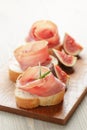 Canapes with jamon and figs on wooden board Royalty Free Stock Photo