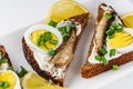 Canapes with sprats on a white rustic wooden background