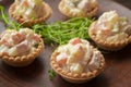 Canapes in tartlets, Russian snack. Wooden background, tartlet with russian salad for catering