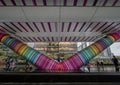 Canary Wharf, London, UK: Beneath the colorful Adams Place footbridge in London Docklands with people walking in the rain. Royalty Free Stock Photo