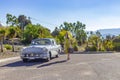 Caucasian lady walking toward a classic 1956 Buick Special sedan