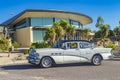 Caucasian lady walking toward a classic 1956 Buick Special sedan