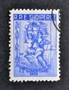 Cancelled postage stamp printed by Albania, that shows Man and Woman Runners with Torch and Flags