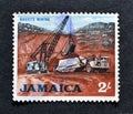 Cancelled postage stamp printed by Jamaica, that shows Bauxite mining