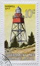 Cancelled postage stamp printed by New Zealand, that shows Farewell Spit lighthouse