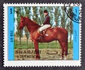 Cancelled postage stamp printed by Sharjah and dependencies, that shows Horse riding