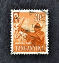 Cancelled postage stamp printed by Tanganyika, that shows Harvesting corn