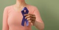Cancer Awareness Campaign Concept. Global Healthcare. World Cancer Day. Close up of a Young Female Brings a Violet Ribbon