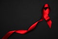Cancer ribbons. Red ribbon symbol in hiv world day on black background. Awareness aids and cancer. Flat lay, top view, copy space Royalty Free Stock Photo