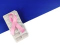 Cancer Treatment by medicine with pink ribbon on blue and white background. Royalty Free Stock Photo