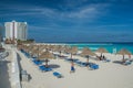 Cancun, Mexico - June 12, 2013: Straw sun umbrella on cancun beach, vacation rest, blue caribbean sea Royalty Free Stock Photo