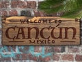 Cancun Mexico Welcome sign engraved in wood on a brick wall tropical