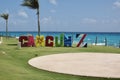 Cancun, Quintana Roo, Mexico - April 24, 2022: Cancun colorful sign by blue ocean in the Caribbean. View with green