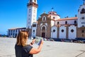 Candelaria, Santa Cruz de Tenerife, Spain - 15.05.2018. Young, confused woman tourist holds in her hands map of the city against