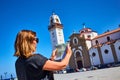 Candelaria, Santa Cruz de Tenerife, Spain - 15.05.2018. Young, confused woman tourist holds in her hands map of the city against