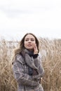 Smiling beautiful girl in a park in a fashionable coat. Checkered autumn coat