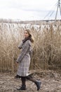 Smiling beautiful girl in a park in a fashionable coat. Checkered autumn coat