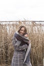 Smiling beautiful girl in a park in a fashionable coat. Checkered autumn coat