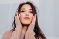 Candid close up portrait of sensual smiling asian girl young woman with dark long hair in cozy beige sweater Royalty Free Stock Photo