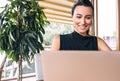 Candid closeup image of a happy business woman smiling and working with laptop in a cafe. Portrait of succesful young female Royalty Free Stock Photo