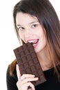 Candid cute beautiful young woman biting a chocolate bar