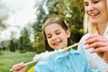 Candid image of happy little girl having fun and eating cotton candy with her mother in the park. Royalty Free Stock Photo