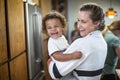 Candid indoor photo of a Smiling, cute mixed race child and his mother