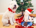 Candid lifestyle portrait of happy surprised funny white Caucasian baby boy in new year Christmas Santa hat sitting on floor Royalty Free Stock Photo