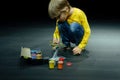 candid little six year old kid boy painting or colorize or colour model airplane with gouache paints