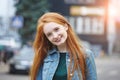 Outdoor portrait of pretty smiling young girl with long red hair, morning sunrise light Royalty Free Stock Photo