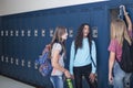 Junior High school Students talking and standing by their locker in a school hallway