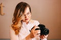 Candid portrait of beautiful blonde girl woman photographer with her camera at work Royalty Free Stock Photo