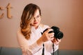 Candid portrait of beautiful blonde girl woman photographer with her camera at work Royalty Free Stock Photo